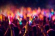 © bluebeat76 - A close-up shot of hands holding glow sticks in the air at a rave party with a blurry crowd of people dancing in the background. Generative Ai