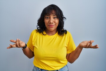 Sticker - Hispanic woman standing over blue background clueless and confused with open arms, no idea concept.