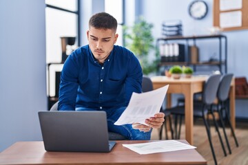 Wall Mural - Young hispanic man business worker using laptop working at office