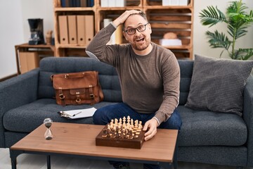 Sticker - Middle age caucasian man playing chess sitting on the sofa stressed and frustrated with hand on head, surprised and angry face