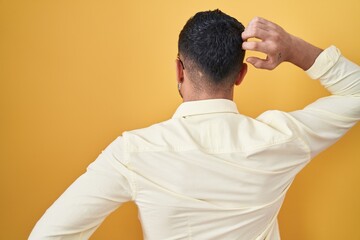 Poster - Hispanic young man wearing business clothes and glasses backwards thinking about doubt with hand on head