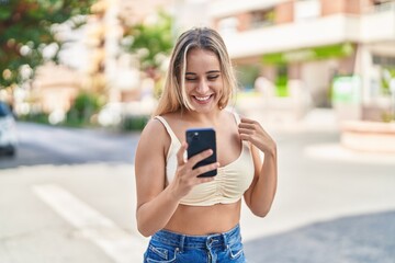 Poster - Young blonde woman smiling confident using smartphone at street