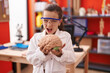 © Krakenimages.com - Little hispanic girl holding brain at science class at school angry and mad screaming frustrated and furious, shouting with anger. rage and aggressive concept.