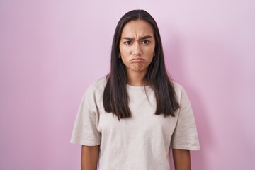 Poster - Young hispanic woman standing over pink background skeptic and nervous, frowning upset because of problem. negative person.