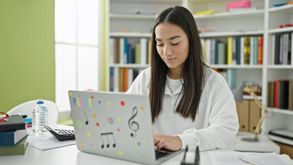 Wall Mural - Young beautiful hispanic woman student using laptop studying at university classroom