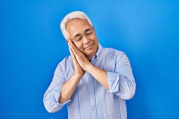 Poster - Hispanic senior man wearing glasses sleeping tired dreaming and posing with hands together while smiling with closed eyes.