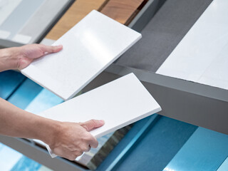 Wall Mural - home interior material design. male hand choosing sample of white ceramic tile for floor and wall fi