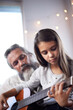 © Miko/peopleimages.com - Girl with grandfather, guitar and learning to play, music education and help with creative development. Musician, art and old man helping female kid learn focus and skill on musical instrument