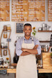 © Mariusz/peopleimages.com - Black man, portrait and barista with arms crossed in cafe with pride for career or job. Waiter, smile and confidence of African person from Nigeria in restaurant, small business and coffee shop.