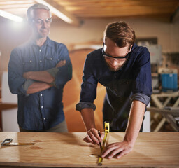 Canvas Print - Mentor carpenter, apprentice and wood measurement at designer furniture manufacturing workshop. Proud mentorship, carpentry and men at sustainable business, teaching and learning with design project.