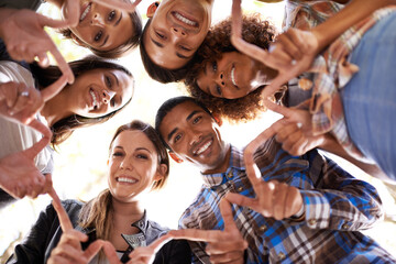 Portrait, finger star and friends in circle with diversity, unity and collaboration with low angle. Happy, smile and group of people in huddle together with hand gesture for solidarity and community.