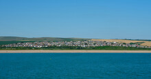 Coastline Near Bishopstone, Seaford In East Sussex Viewed From The Sea On A Summers Day With Clear Bue Sky.
