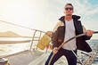 © GR/peopleimages.com - Water adventure, rich man sailing on a yacht and retirement on sea with in blue sky. Travel or freedom, sunshine or relax and mature male on summer vacation or holiday break on cruise boat.