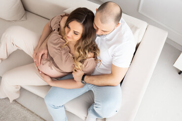 family concept. happiness concept. close-up portrait of a pregnant belly that embraces female and male hands. close-up portrait of embracing spouses. view from above