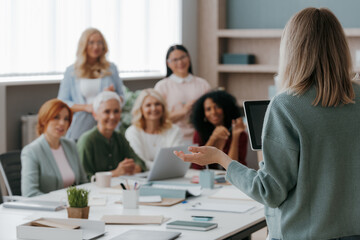 Sticker - Group of mature women listening to speaker while having business training in office