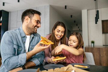 Happy family eating pizza at home