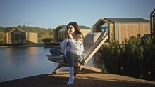 Young Calm Pregnant Woman Drinking Tea On Pier