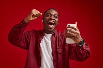 emotional man african appearance with phone in hands technology communication joy