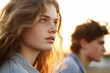 © wetzkaz - teenage girl or young adult woman is disgusted with her boyfriend, stressed annoyed and disappointed, quarrel in relationship, sunset outside by the lake. Generative AI