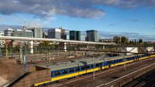 Timelapse Footage Featuring The Hague's Central Railway Station On A Partly Cloudy Autumn Day. Daytime Scene Showcases Trains Coming And Going, Busy Tracks, And Surrounding Urban Landscape.