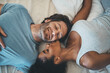 © A. Frank/peopleimages.com - Interracial couple, kiss and relax on bed above for morning bonding, intimate relationship or love at home. Top view of woman kissing man while lying in bedroom for loving romance, care or affection