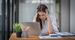 © David - Portrait of tired young business Asian woman work with documents tax laptop computer in office. Sad, unhappy, Worried, Depression, or employee life stress concept