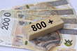 Inscription 800 plus next to 200 Polish zloty banknotes. 800 plus is evaluation of the 500 plus program in Poland, state program in the field of social policy.
