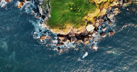 Wall Mural - Aerial view of rocky coastline with crashing sea waves on the cliffs, 4k video