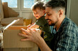 © Westend61 - Father and son packing cardboard boxes at home