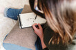 © Westend61 - Woman sketching on spiral book at home