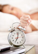 © Mark Freebs/peopleimages.com - Snooze, alarm and hand of woman in morning wake up with tired, exhausted and no sleep at home. Depression, sleeping and annoyed female person with anxiety, frustrated and stress hit bedroom clock
