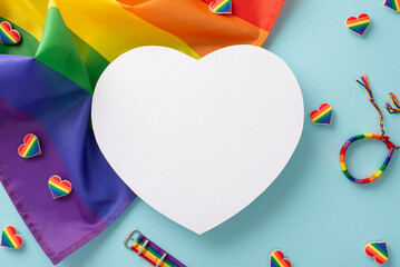 Wall Mural - A flat lay of LGBT History Month parade accessories. Rainbow flag, wristlet, pin badges, bracelet, colorful heart symbols, arranged on a pastel blue surface with an empty heart for text