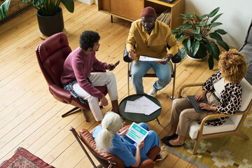 Leinwandbilder - Above angle of intercultural coworkers gathered in office for discussion of working points and financial developemnt of business company