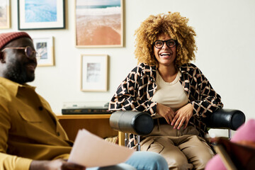 Leinwandbilder - Young cheerful African American businesswoman laughing during working discussion or brainstorming at start-up meeting with colleagues