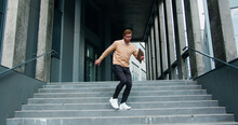 Happy Young Man Actively Dancing While Walking Down The Stairs. Cheerful Man Walks On Stairs Outside His Office, Starts Funny Victory Dance Celebrating.