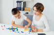 © dmitriisimakov - female psychologist develops boy fine motor skills development learning
