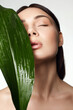© eugenepartyzan - beautiful girl with palm leaves. Beautiful young woman with Make-up