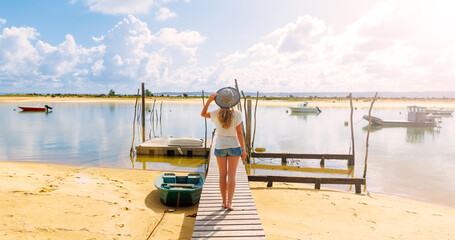 Wall Mural - Woman walking on wooden pier,  beautiful beach and fishing boats- Arcachon basin,  France, Basque country