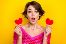 Photo Of Impressed Girl Dressed Off Shoulder Shirt Hands Hold Two Paper Hearts Open Mouth Staring Isolated On Yellow Color Background