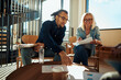 © Flamingo Images - Two smiling businesspeople going over paperwork during an office meeting