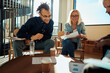 © Flamingo Images - Two smiling businesspeople going over documents during an office meeting