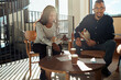 © Flamingo Images - Two smiling African American businesspeople going over paperwork with colleagues