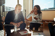 © Flamingo Images - Two diverse work colleagues laughing during an office meeting