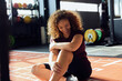© Flamingo Images - Laughing woman sitting on a gym floor