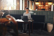 © Flamingo Images - Young businesswoman sitting in a lounge working on a laptop