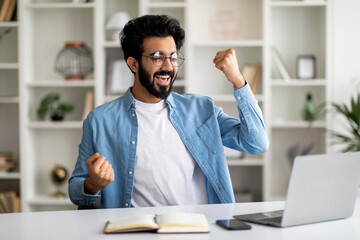 Wall Mural - Promotion News. Overjoyed Indian Man Looking At Laptop Screen And Celebrating Success