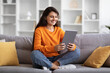 © Prostock-studio - Positive hindu woman holding modern digital tablet in her hands