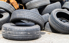 Industrial Dump For The Processing Of Used Tires And Rubber Tires. Pile Of Old Tires And Wheels For Rubber Recycling. Tire Dump. Recycling Of Used Tires. Produced Reclaimed Tire Rubber.