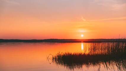 Wall Mural - 4K Sundown Above Lake River Horizon At Sunset. Natural Sky In Warm Colors Water. Sun Waters. Time-Lapse Time Lapse At Dusk.