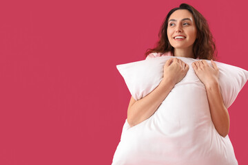 Poster - Young brunette woman with pillow on pink background